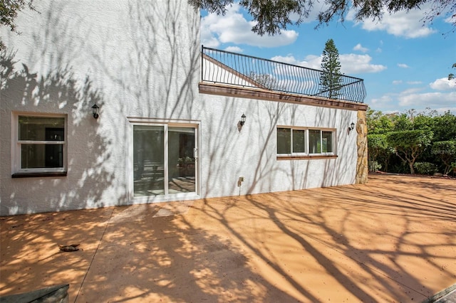 rear view of house with stucco siding