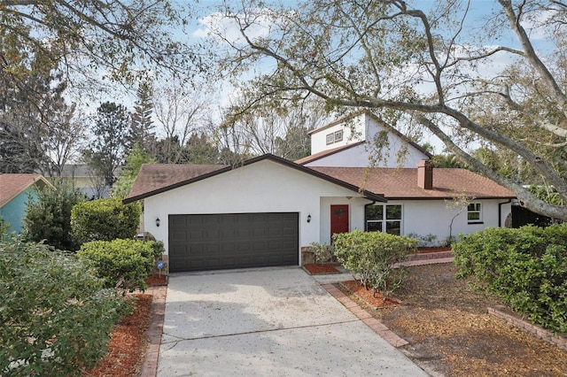 view of front of home with concrete driveway, roof with shingles, stucco siding, a chimney, and a garage