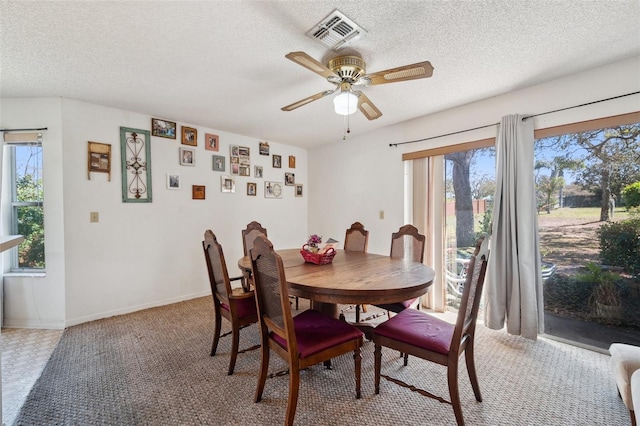 dining area with visible vents, ceiling fan, a textured ceiling, and baseboards