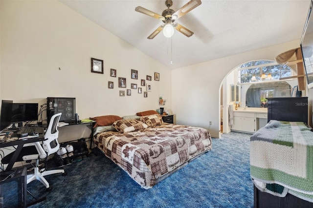 carpeted bedroom with arched walkways, ceiling fan, and vaulted ceiling