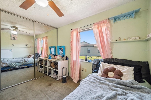 bedroom with carpet, a textured ceiling, ceiling fan, and a closet