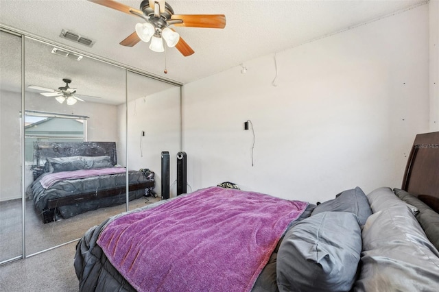 bedroom featuring a ceiling fan, a closet, visible vents, and a textured ceiling