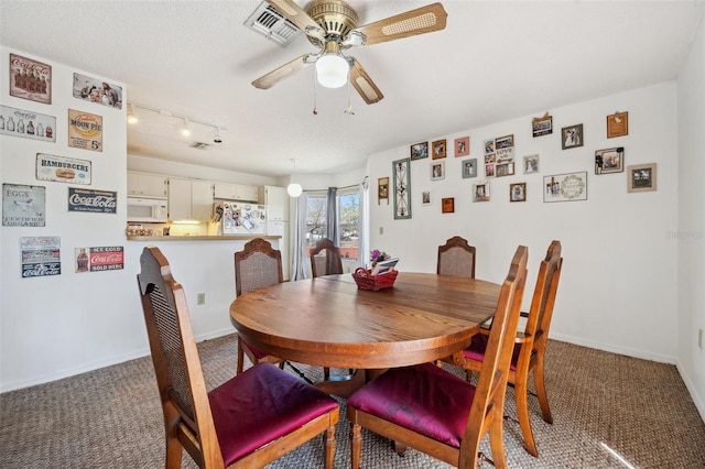 dining space with carpet floors, visible vents, ceiling fan, and baseboards