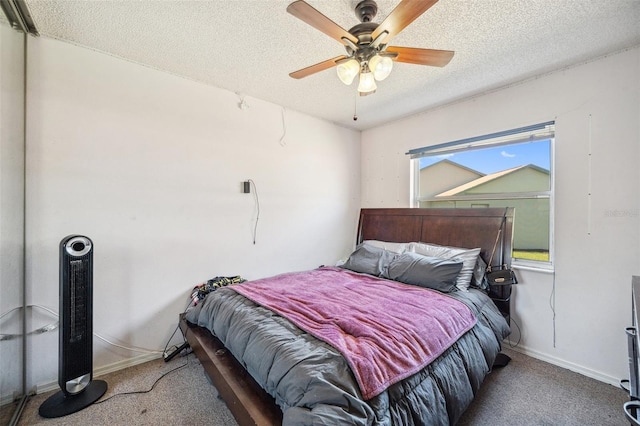 bedroom with a ceiling fan, a textured ceiling, baseboards, and carpet flooring