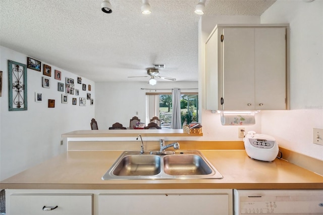 kitchen featuring a textured ceiling, a sink, visible vents, light countertops, and dishwasher