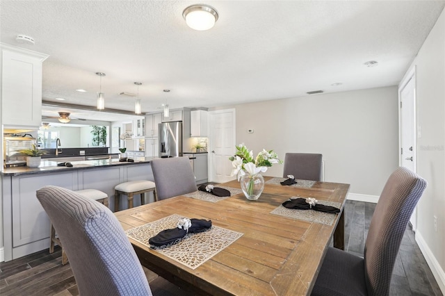 dining room with visible vents, baseboards, a textured ceiling, and dark wood finished floors