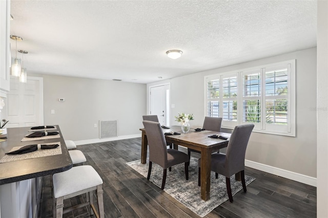 dining space with visible vents, baseboards, a textured ceiling, and dark wood-style flooring