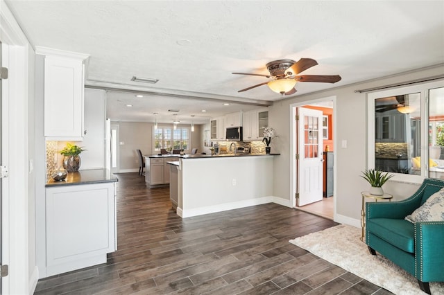 kitchen featuring tasteful backsplash, a peninsula, white cabinets, ceiling fan, and dark wood-style flooring