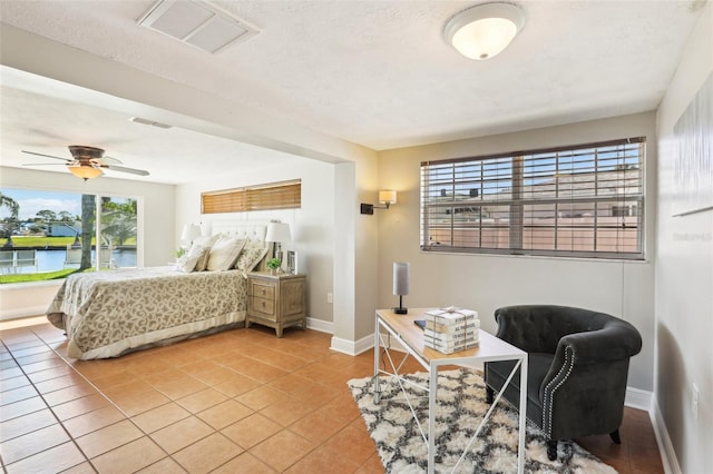 bedroom with light tile patterned floors, visible vents, and baseboards