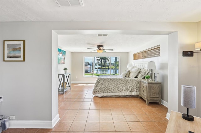 bedroom featuring light tile patterned floors, visible vents, and a textured ceiling