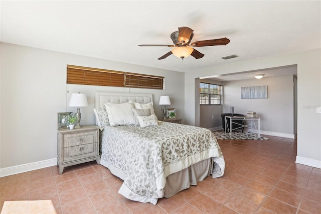 bedroom with light tile patterned floors, visible vents, baseboards, and a ceiling fan