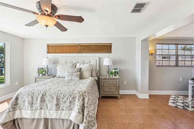 bedroom with tile patterned flooring, visible vents, multiple windows, and baseboards