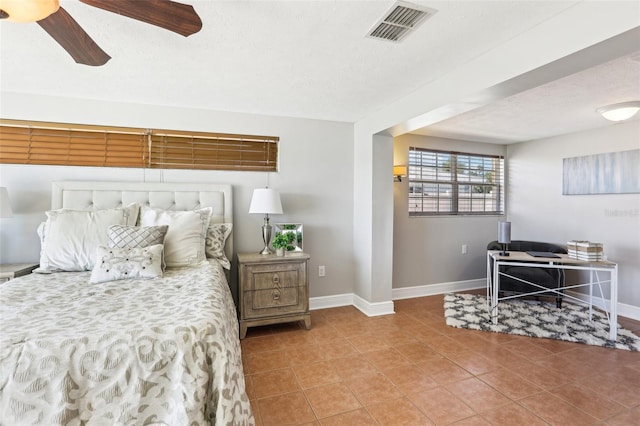 tiled bedroom featuring visible vents, ceiling fan, a textured ceiling, and baseboards