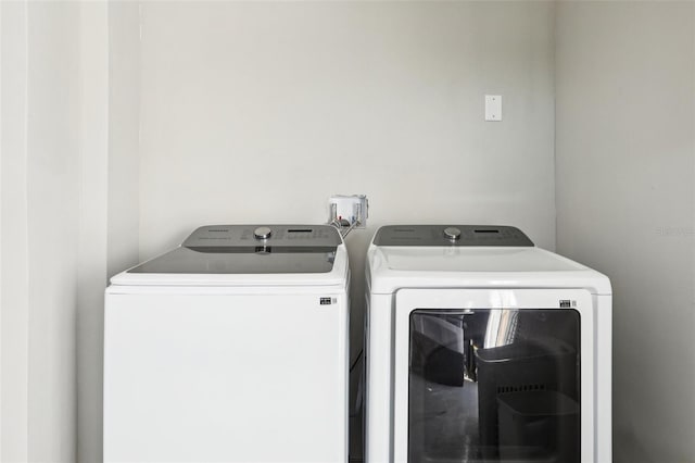 clothes washing area featuring laundry area and washer and clothes dryer