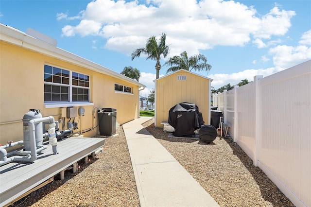 view of yard featuring an outdoor structure, a shed, and fence