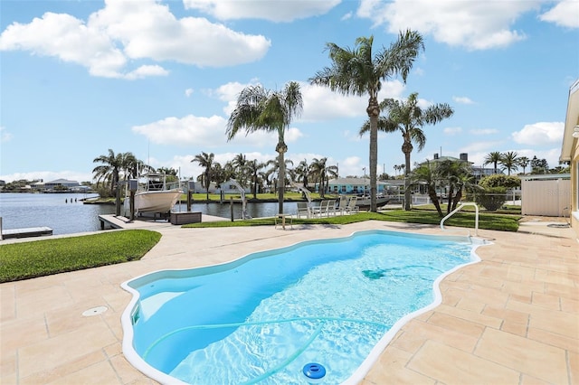 outdoor pool with a water view, boat lift, a patio, and a boat dock