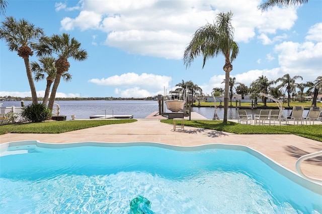 pool featuring a dock, a patio, a water view, and boat lift