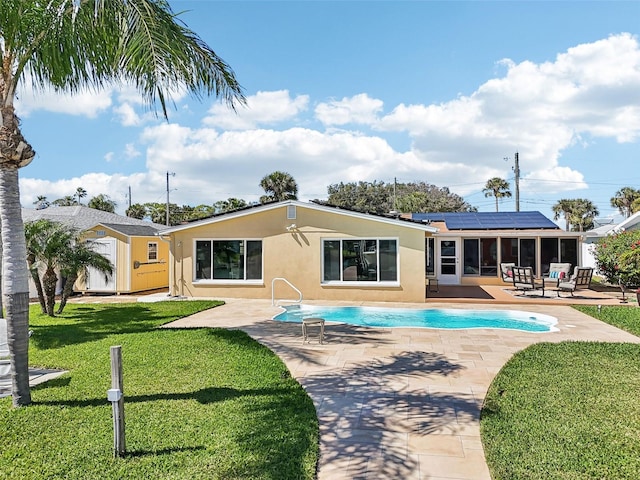 back of property featuring stucco siding, a lawn, a patio, and a sunroom