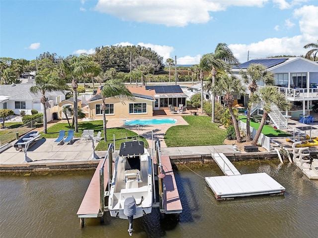 view of dock with a water view, a lawn, a fenced backyard, boat lift, and a patio area