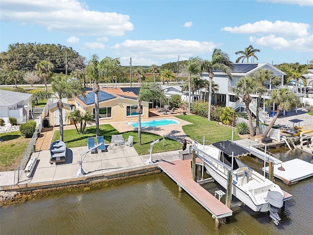 view of dock featuring a patio, boat lift, a lawn, and a water view