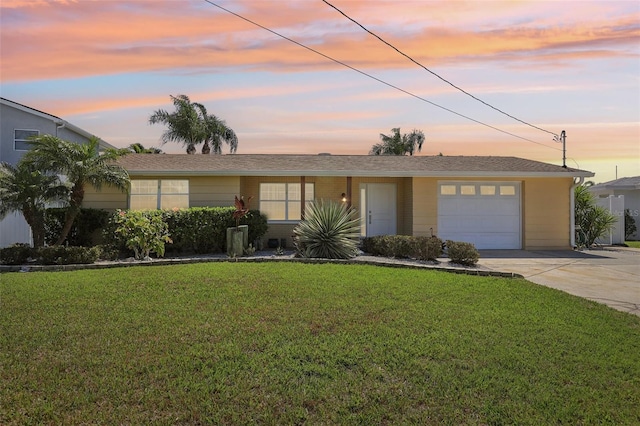 ranch-style house with concrete driveway, an attached garage, and a front lawn