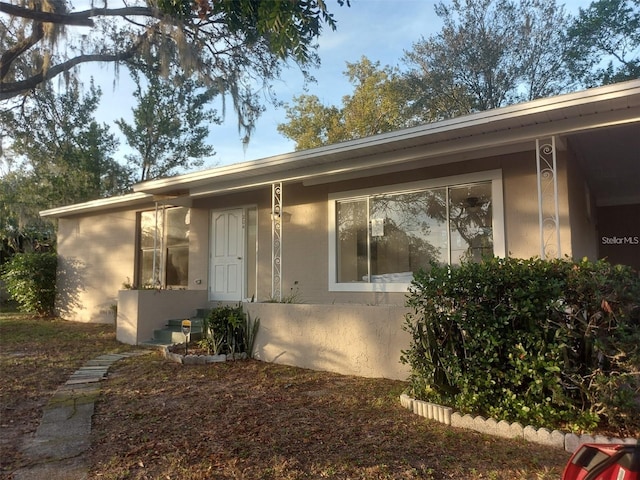 ranch-style house featuring stucco siding