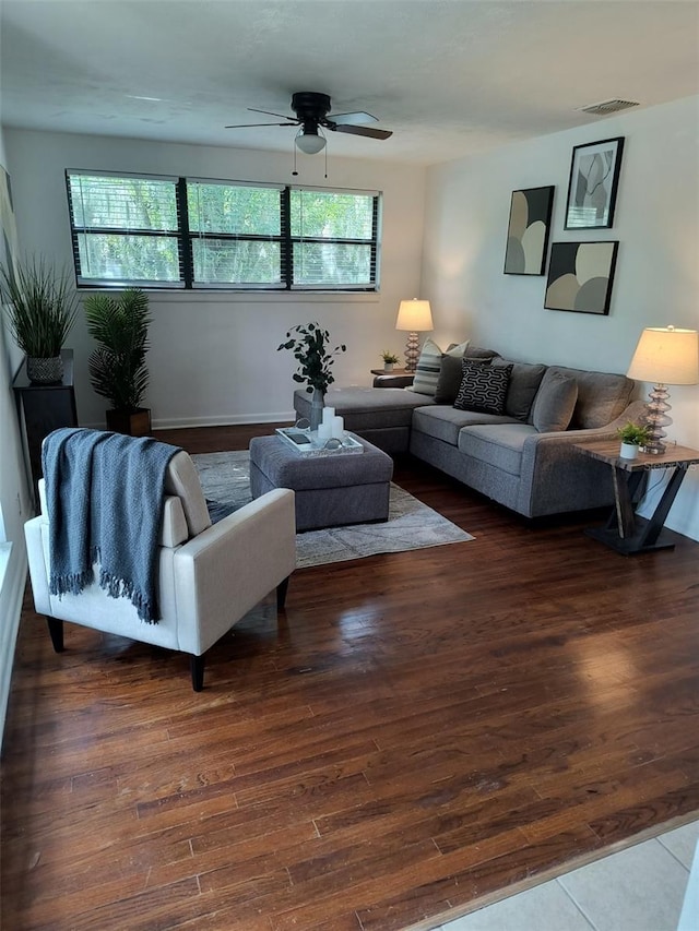 living room featuring a wealth of natural light, a ceiling fan, visible vents, and wood finished floors