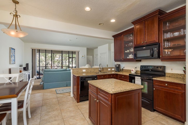 kitchen with light tile patterned floors, open floor plan, a sink, a peninsula, and black appliances