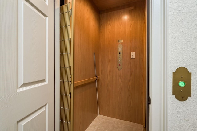 room details featuring elevator and a textured wall