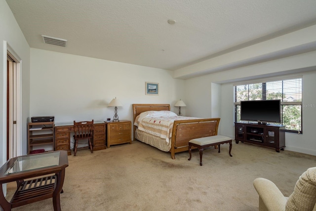 bedroom with light carpet, a textured ceiling, and visible vents