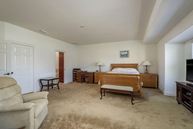 bedroom featuring visible vents, light carpet, and a textured ceiling