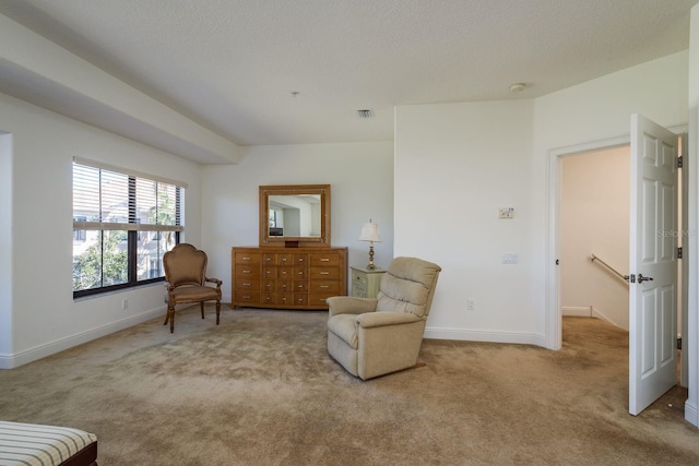 living area with carpet floors, baseboards, visible vents, and a textured ceiling