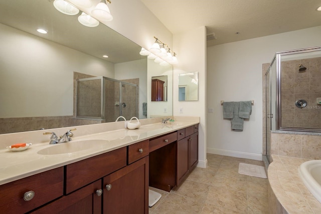 bathroom with double vanity, a stall shower, a garden tub, and a sink