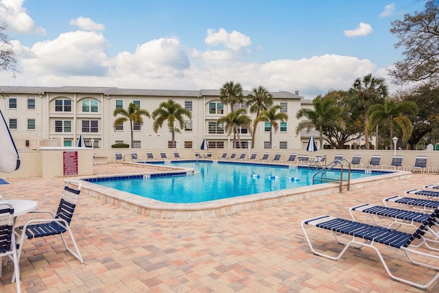 community pool with a patio and fence