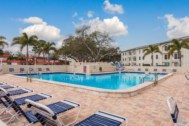 community pool featuring fence and a patio