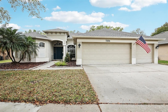 view of front of home featuring a front lawn, an attached garage, driveway, and stucco siding