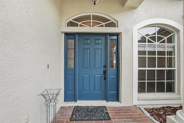 doorway to property featuring stucco siding