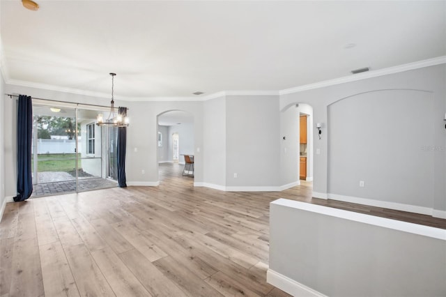 interior space with baseboards, arched walkways, ornamental molding, light wood-style floors, and a notable chandelier