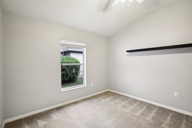 carpeted spare room featuring ceiling fan, baseboards, and vaulted ceiling