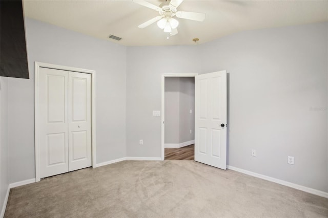 unfurnished bedroom featuring carpet, a closet, visible vents, a ceiling fan, and baseboards