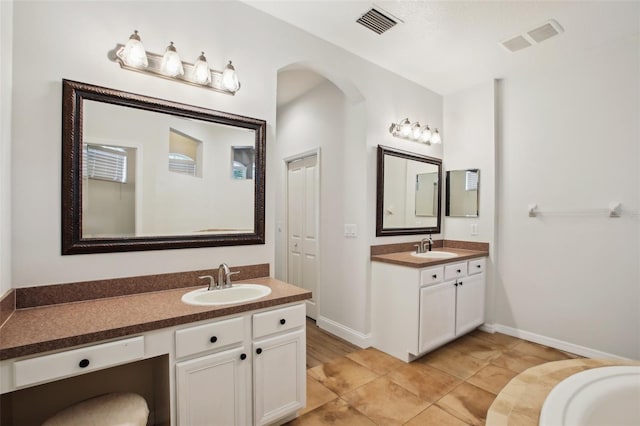 bathroom with two vanities, visible vents, and a sink