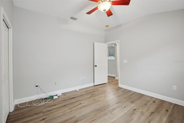 unfurnished bedroom with baseboards, visible vents, ceiling fan, wood finished floors, and a closet