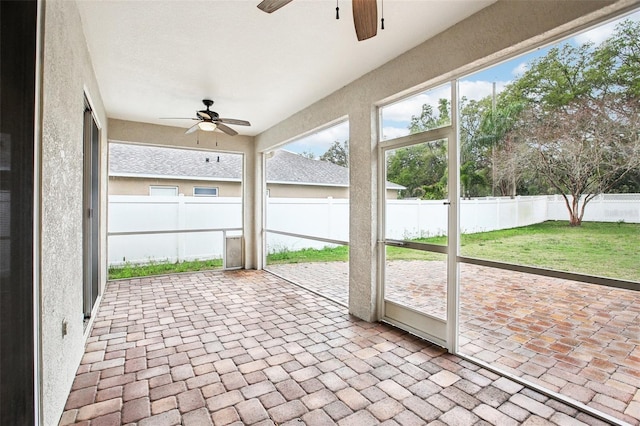 unfurnished sunroom featuring a ceiling fan