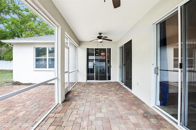 unfurnished sunroom featuring a ceiling fan