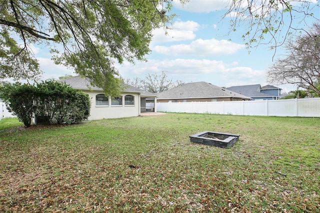 view of yard with an outdoor fire pit and fence