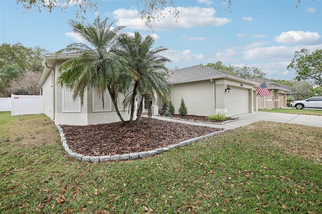 view of side of property featuring a garage, fence, concrete driveway, a yard, and stucco siding