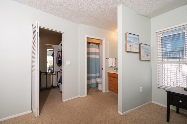 corridor featuring baseboards, plenty of natural light, and light colored carpet