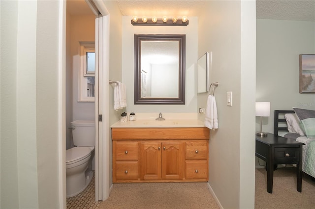 bathroom featuring vanity, toilet, baseboards, and a textured ceiling