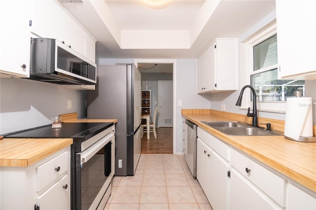 kitchen with light countertops, light tile patterned floors, appliances with stainless steel finishes, and a sink