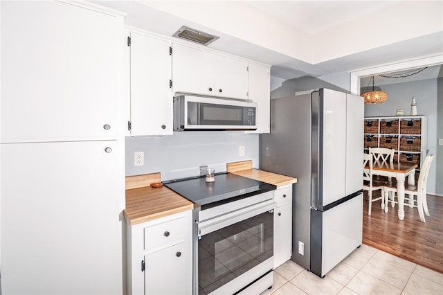 kitchen featuring visible vents, white appliances, white cabinets, light countertops, and light tile patterned floors